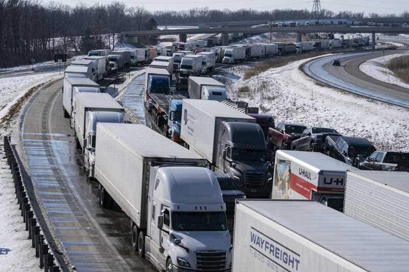 Trucks heading to Canada are stuck in heavy traffic after they were diverted to the Blue Water Bridge in Port Huron, Mich., Wednesday, Feb. 9, 2022, after the Ambassador Bridge was closed due to Canadian anti-vaccine protests.