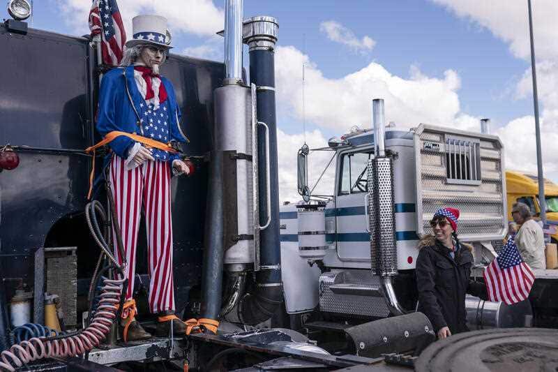 A supporter walks past a mannequin of Uncle Sam at the beginning of a trucker caravan to Washington, D.C., called The People's Convoy