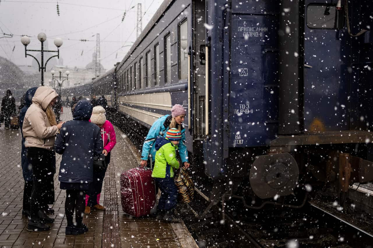 A Ukrainian family take the Dnipro-Truskavets train at the Lviv railway station, Sunday, Feb. 27, 2022, in Lviv, west Ukraine.