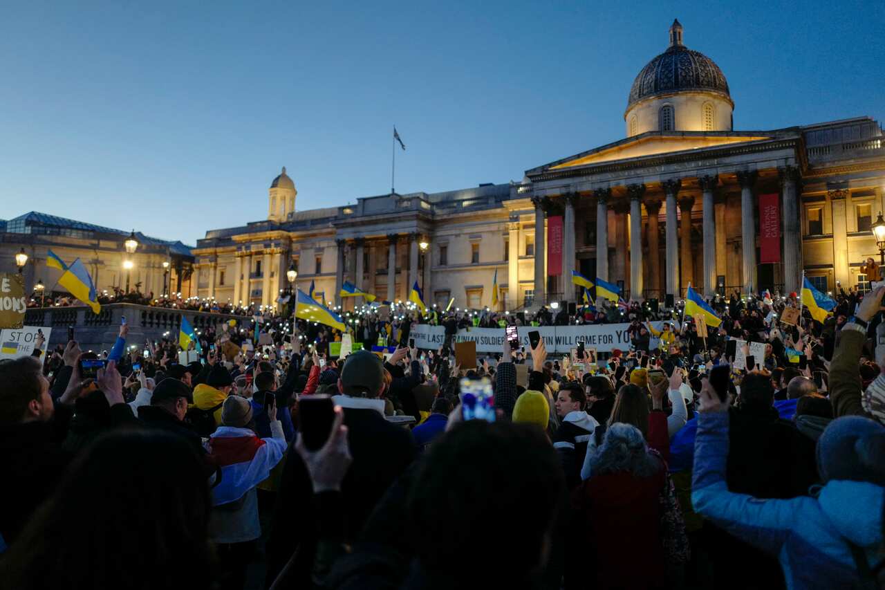 Demonstrators hold placards and Ukraines flag during a protest in Trafalgar Square during a protest, in London, Sunday, Feb. 27, 2022. A Ukrainian official says street fighting has broken out in Ukraine's second-largest city of Kharkiv. Russian troops als