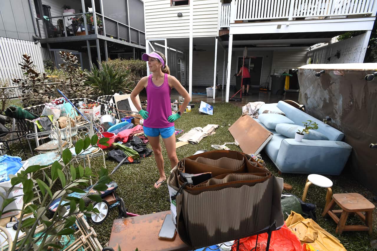 Jane Knox is seen cleaning up her flood damaged property in the suburb of Auchenflower in Brisbane, Wednesday, March 2, 2022. Floodwaters in southeast Queensland may not fully recede for seven days with one man still missing, nine people dead and more tha