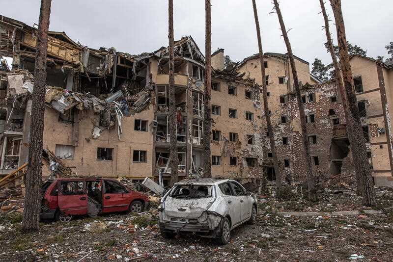 Destroyed cars are seen next to residential buildings damaged by heavy shelling in Irpin city, Ukraine, 