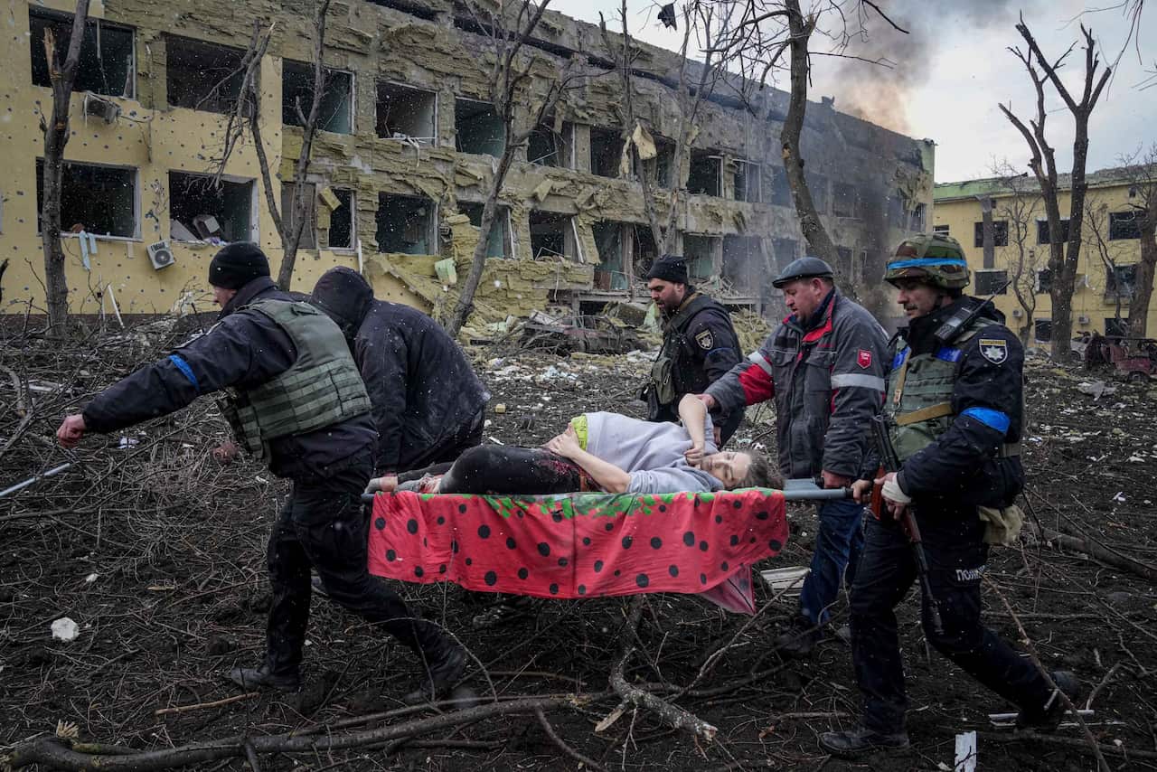 Ukrainian emergency employees and volunteers carry an injured pregnant woman from the damaged by shelling maternity hospital in Mariupol, Ukraine, Wednesday, March 9, 2022. A Russian attack has severely damaged a maternity hospital in the besieged port ci