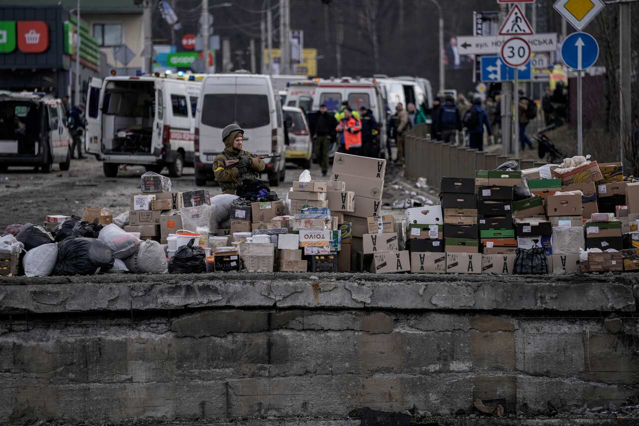 A Ukrainian serviceman stands by food supplies in Irpin, on the outskirts of Kyiv,