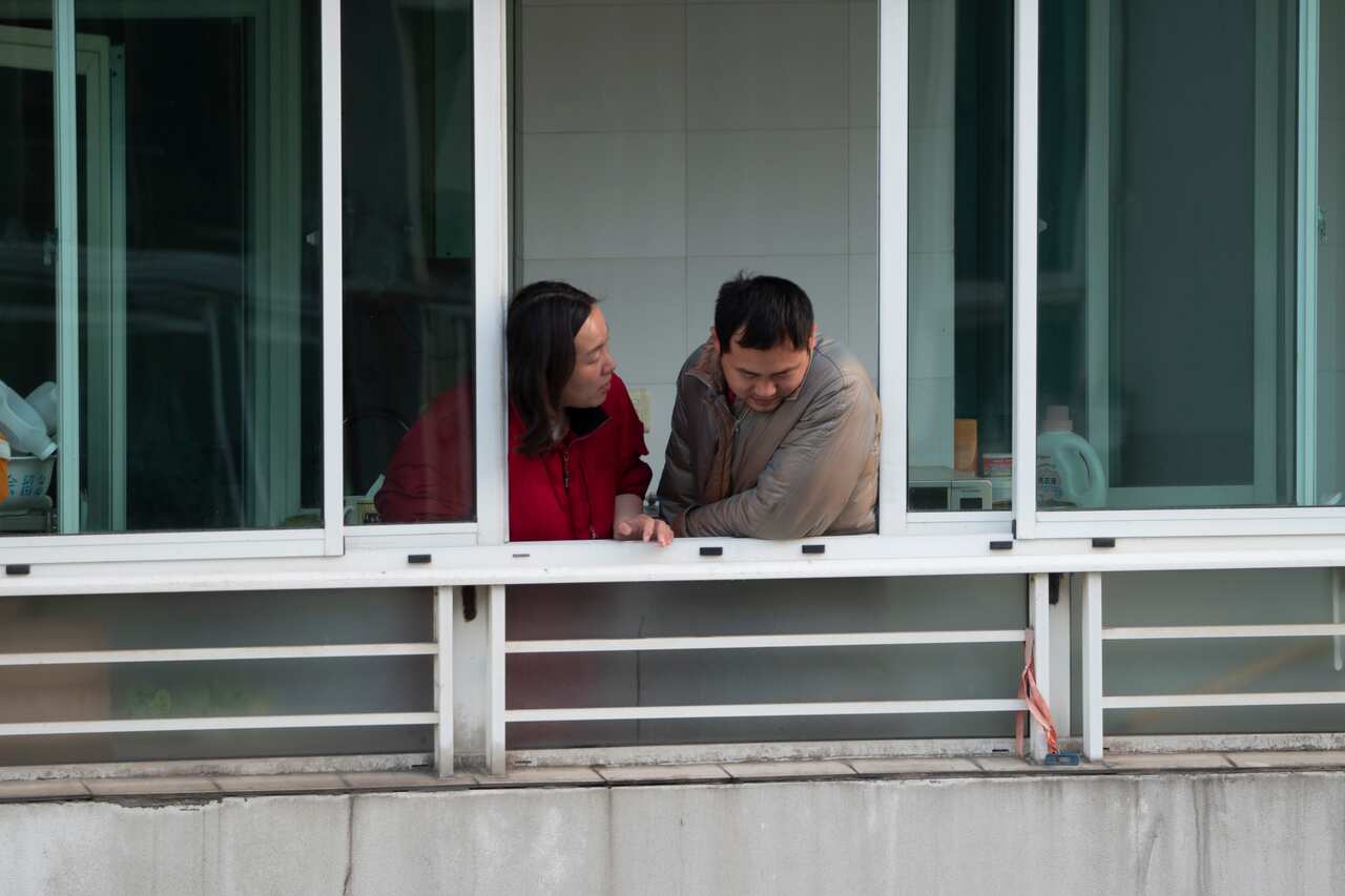 Citizens look out from a window of a high-rise building in Shanghai whilst under lockdown. 