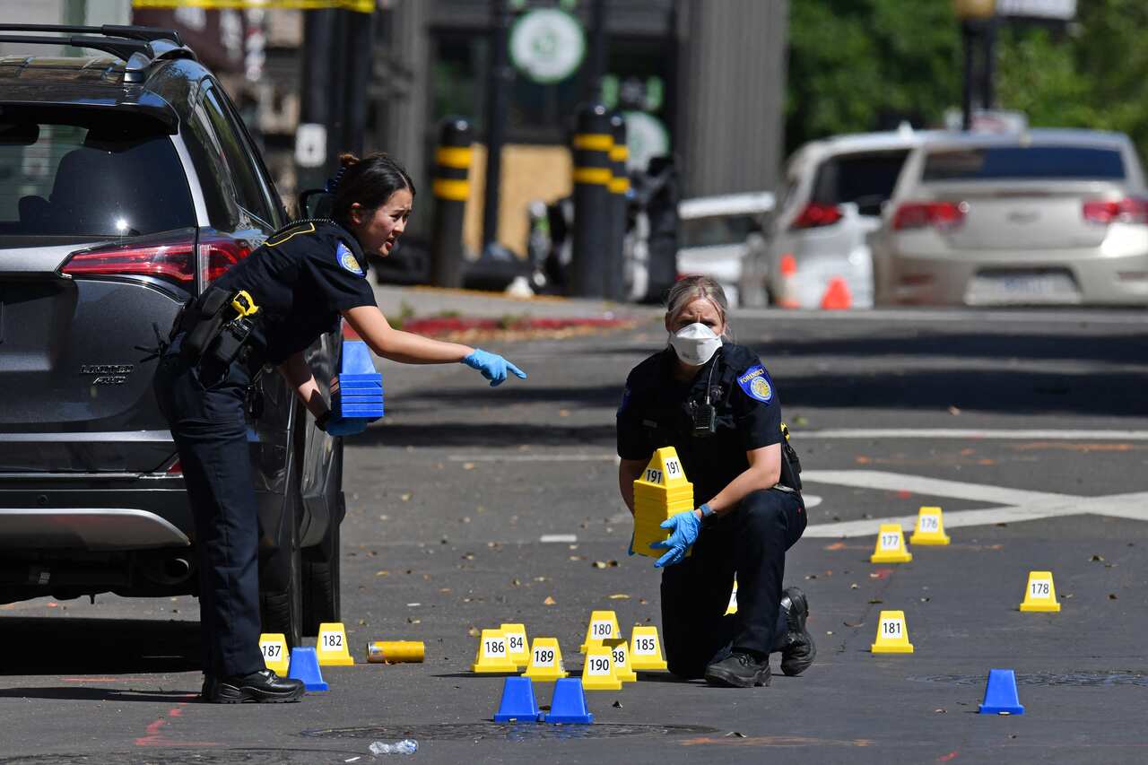 Sacramento Police crime scene investigators place evidence markers on 10th Street at the scene of a mass shooting in Sacramento, CA, USA, on Sunday, April 3, 2022. Six people are dead and 12 others are injured after a shooting broke out early Sunday morni