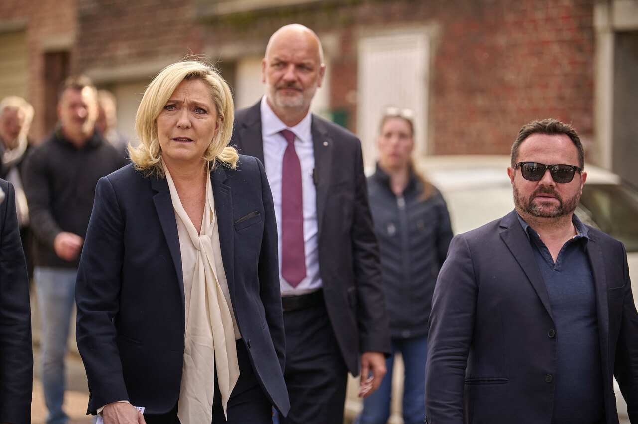 Far-right National Rally candidate Marine Le Pen poses greets supporters as she leaves a polling station.
