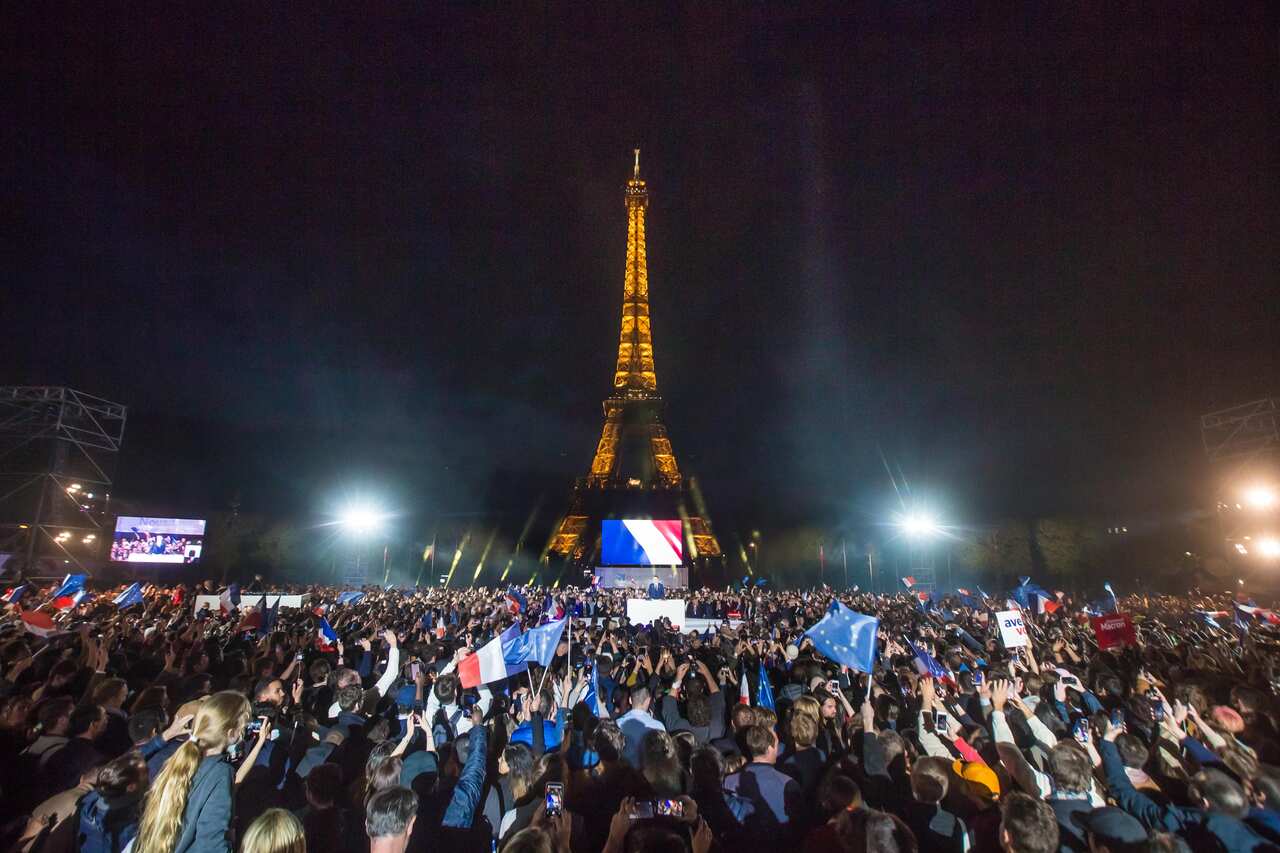 Supporters of French President and candidate for re-election Emmanuel Macron (not pictured) celebrate at the Champs-de-Mars in front of the Eiffel Tower after Emmanuel Macron won the second round of the French presidential elections in Paris, France, 24 A