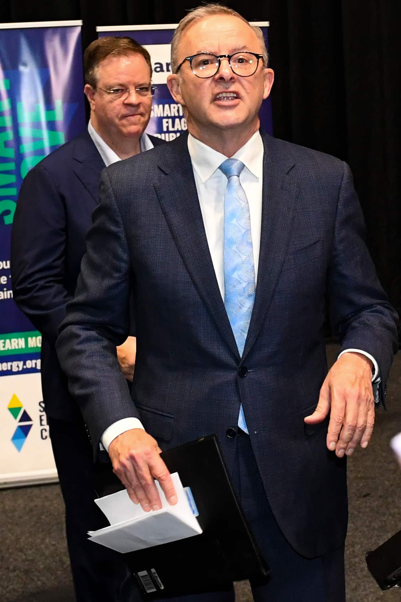 Australian Opposition Leader Anthony Albanese holds his briefings folder as he leaves after speaking to the media during a visit to the Smart Energy Council Conference and Exhibition 
