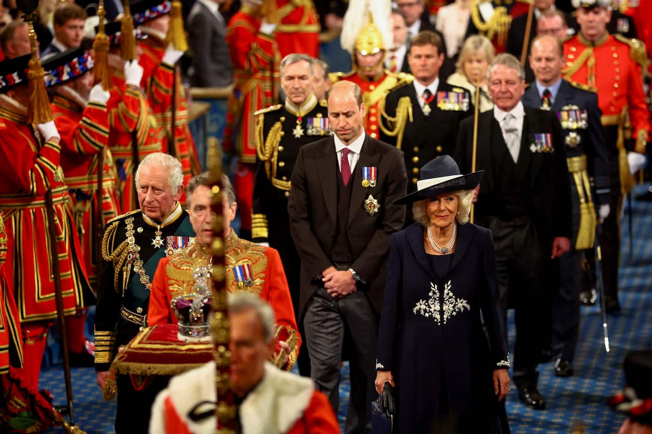 Britain's Prince Charles, Camilla, Duchess of Cornwall and Britain's Prince William proceed behind the Imperial State Crown through the Royal Gallery