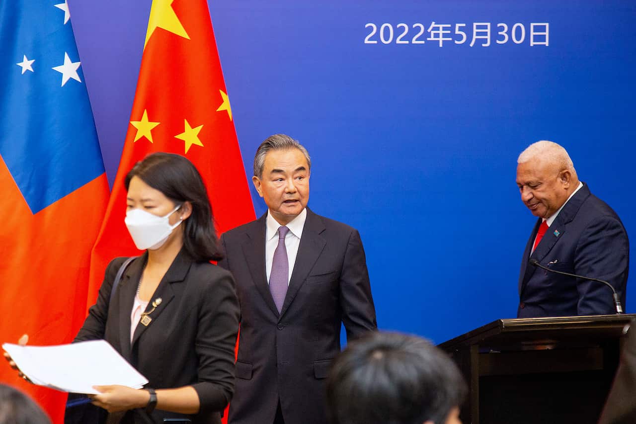 China's Foreign Minister Wang Yi, center, appears on stage at the Pacific Islands Foreign Ministers' meeting with Fiji's Prime Minister Frank Bainimarama, Monday, May 30, 2022, in Suva, Fiji. (Leon Lord/Fiji Sun via AP)