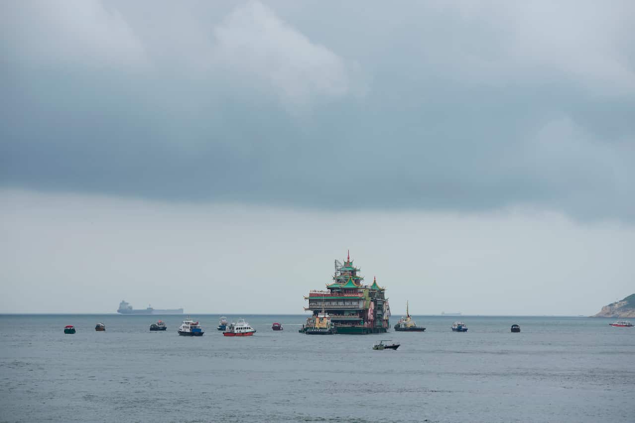 Hong Kong's iconic Jumbo Floating Restaurant is towed away in Hong Kong, Tuesday, June 14, 2022. Hong Kong's iconic restaurant on Tuesday departed the city, after its parent company failed to find a new owner and lacked funds to maintain the establishment