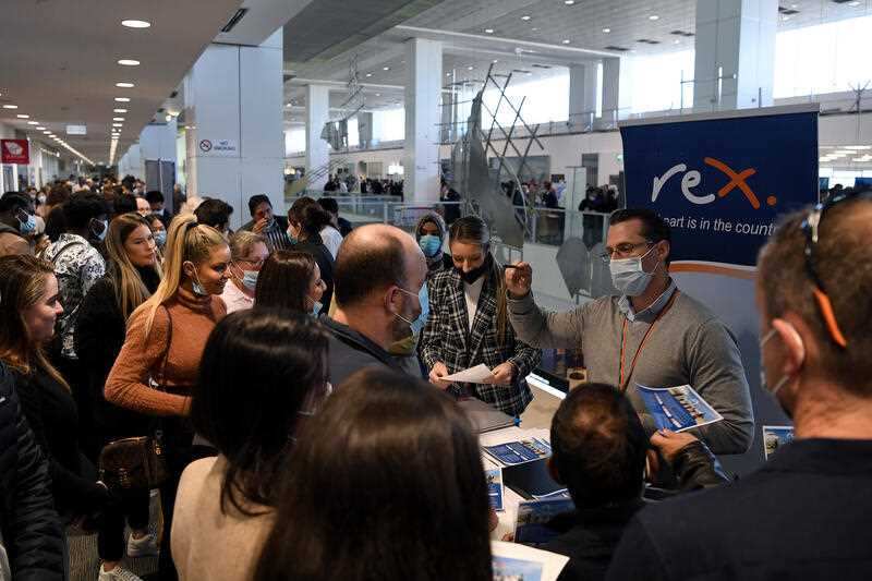 Job seekers gather around different business booths during a Sydney Airport 