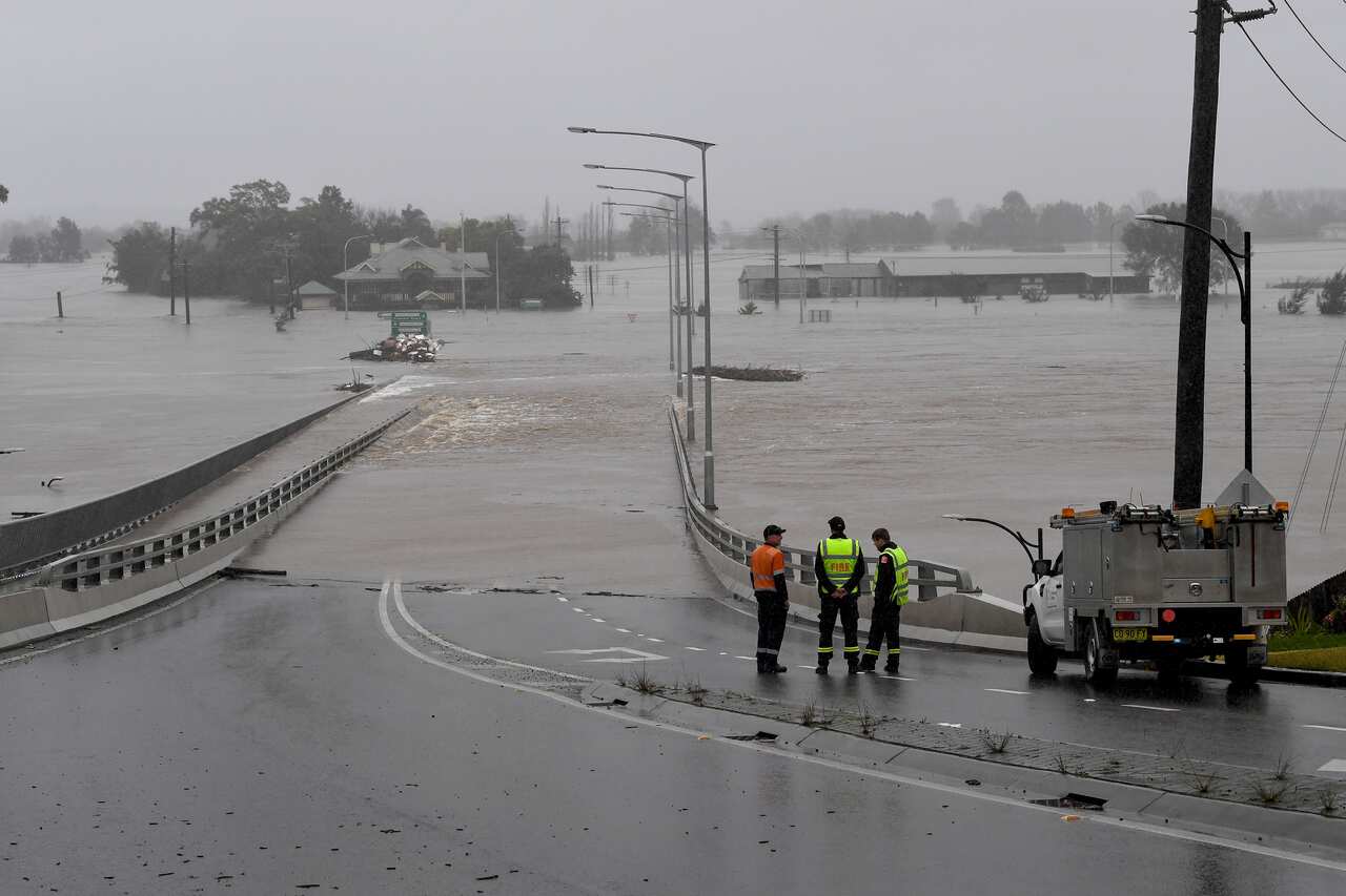 NSW Fire and Rescue look on as the Windsor Bridge is submerged under floodwater from the swollen Hawkesbury River, in Windsor, north west of Sydney, Monday, July 4, 2022. 