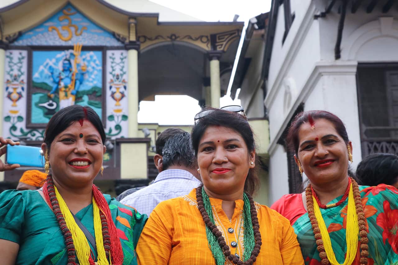 Women devotees poses for the photos infront of the UNESCO World Heritage Site pashupatinath Temple gate early morning on the first monday of the holy month "Shrawn".