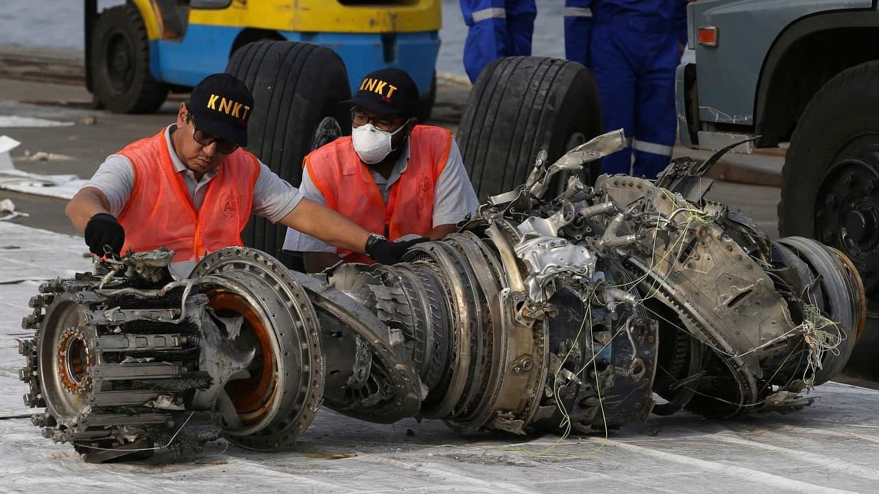 Officials inspect the engine of the crashed Lion Air jet, following the fatal crash.
