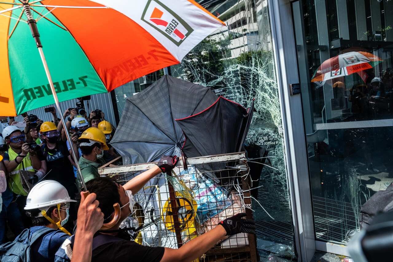Protesters use a steel cart to breach the doors of the Legislative Council in Hong Kong on Monday, July 1, 2019, hours after the government held a ceremony commemorating the 22nd anniversary of the territory’s return to China from Britain. There are signa