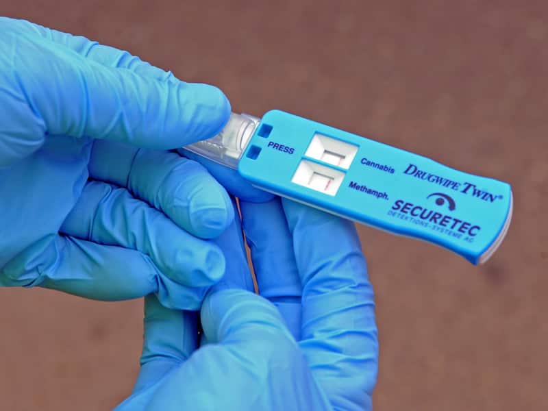 A police officer holds a random drug test device