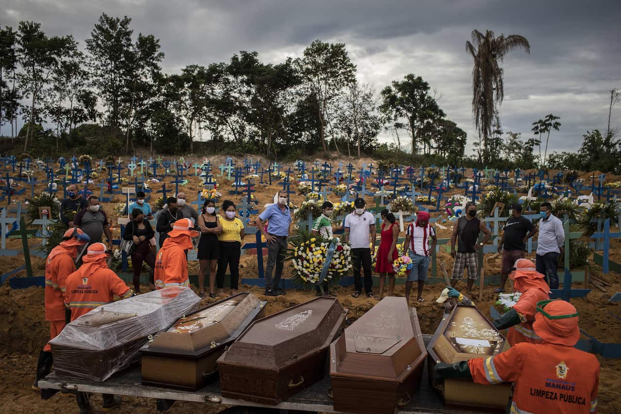 People attend a funeral due to coronavirus at a mass grave at the Nossa Senhora Aparecida cemetery in Manaus, Brazil.
