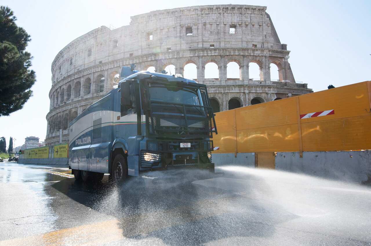 To fight the Coronavirus Italian police use vehicles equipped with water cannons to clean the streets Rome at the Colosseum, Rome, Italy.