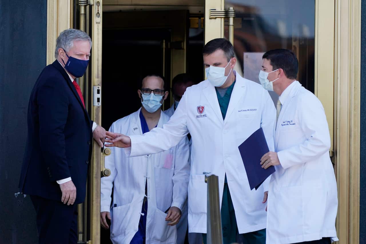 White House Chief of Staff Mark Meadows holds the door for Dr Sean Conley, physician to President Donald Trump and other doctors.