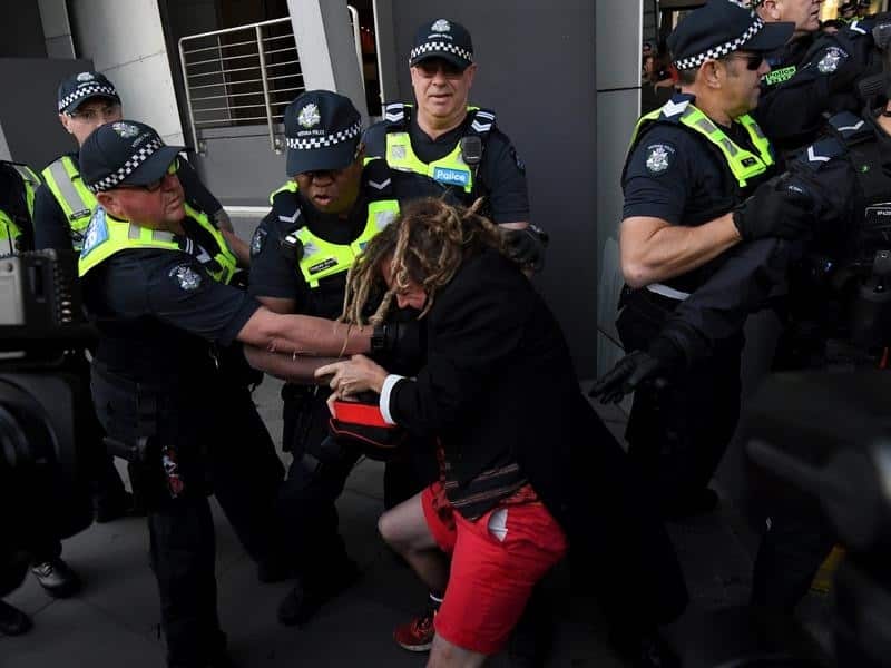 Police try to grab a protester outside a Melbourne centre.