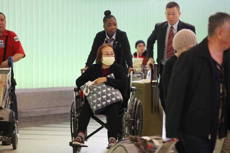 Travelers arrive at Tom Bradey International Terminal in Los Angeles, California.