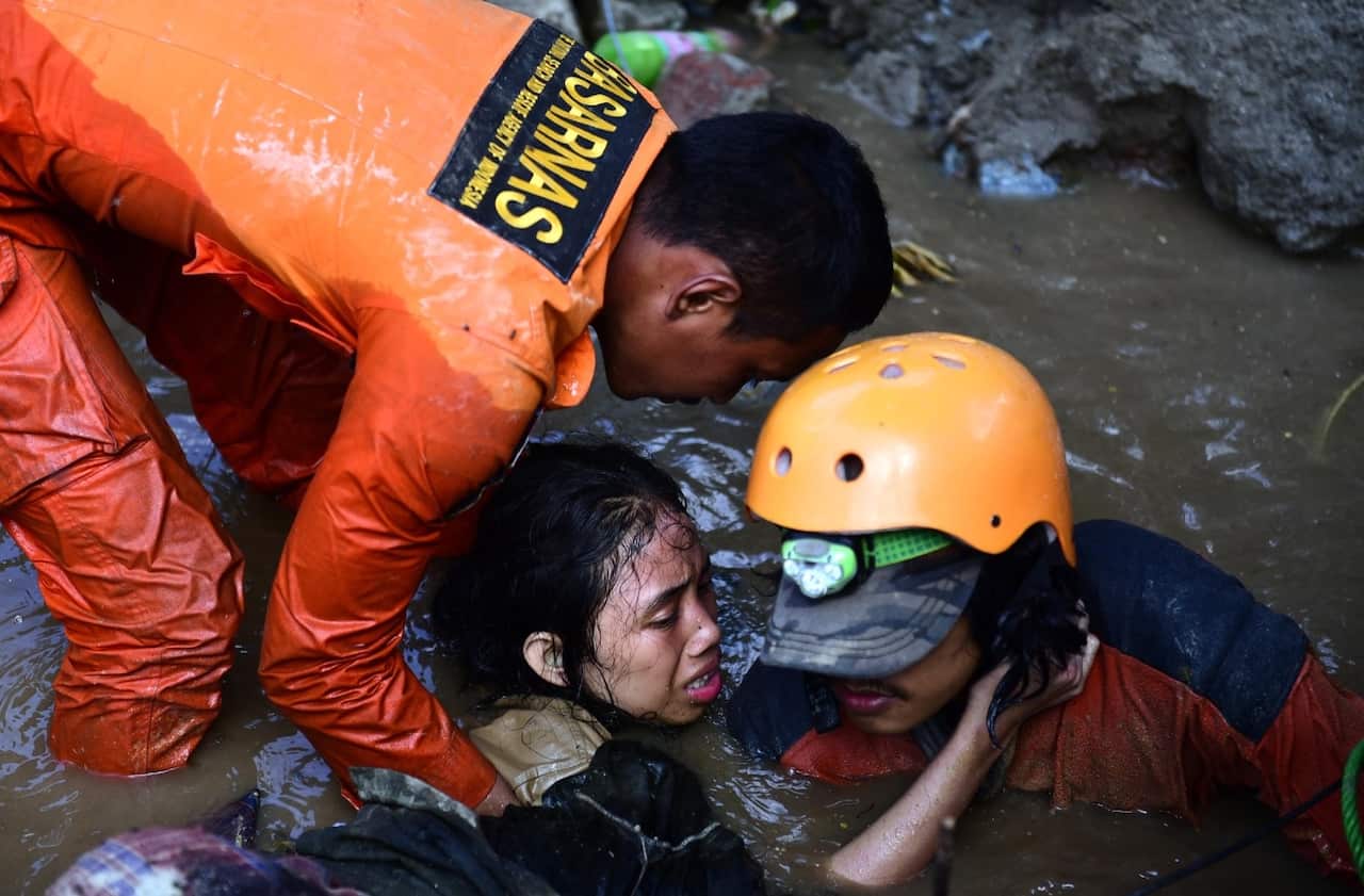 Indonesian rescuers try to free a 15-year-old earthquake survivor, Nurul Istikhomah from the flooded ruins of a collapsed house in Palu, Central Sulawesi