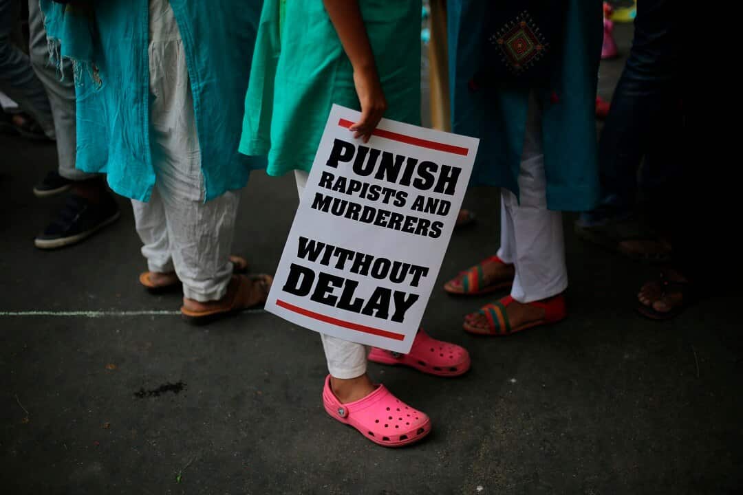 An Indian protester stands with a placard during a protest after recently reported rape cases. 