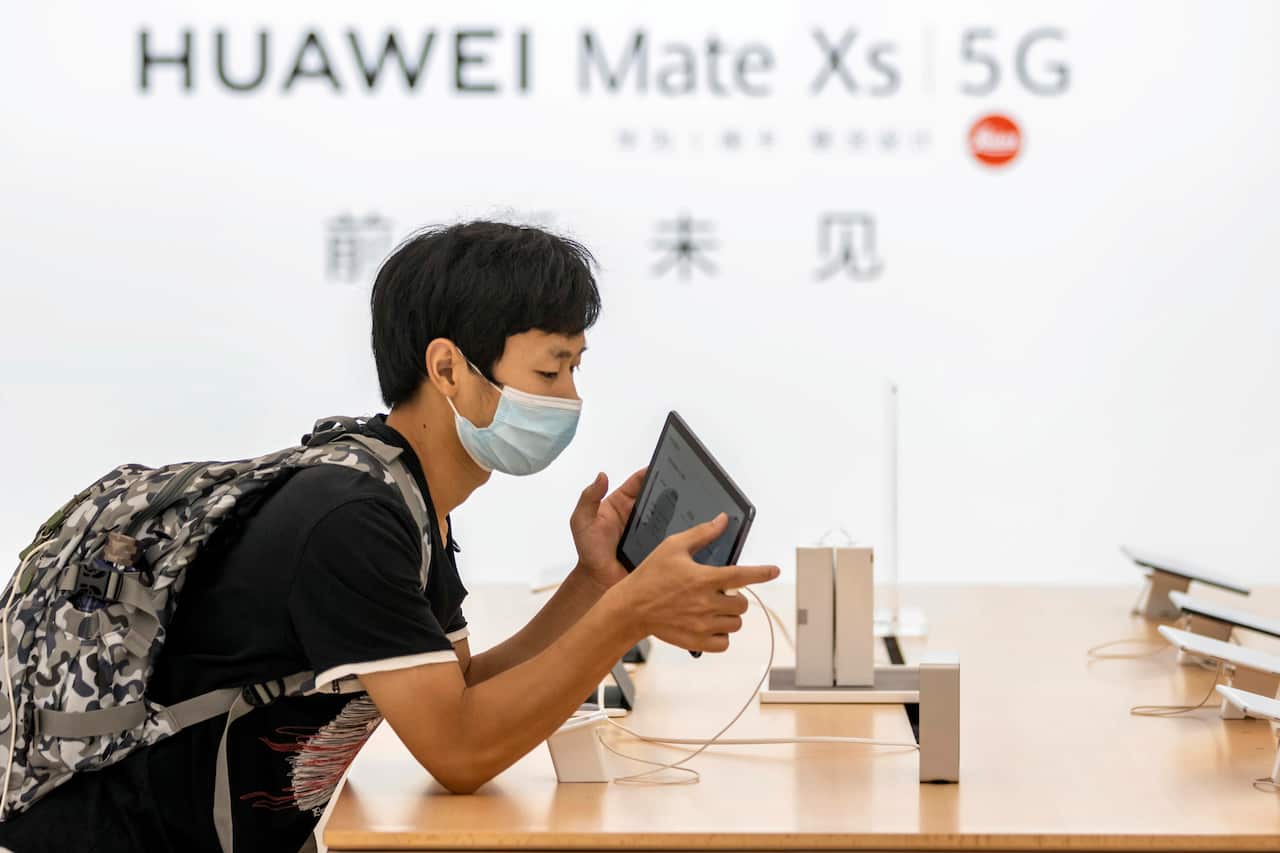 People wearing face masks visit Huawei's newest flagship store in Shanghai.