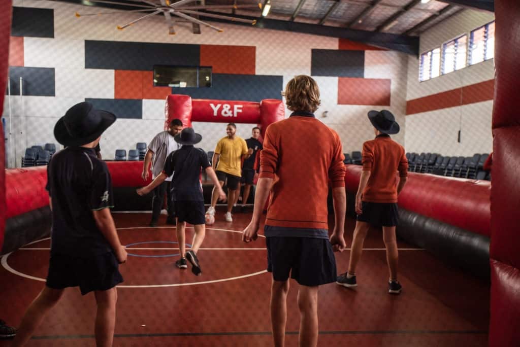 Youth pastors run a sports session at a school. 