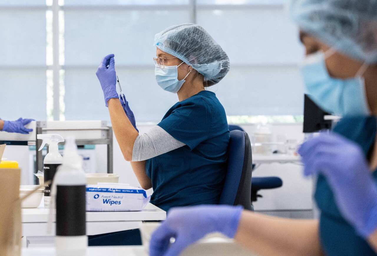 Staff preparing COVID-19 vaccines in the pharmacy area of the NSW Vaccination Centre in Homebush, Sydney. 