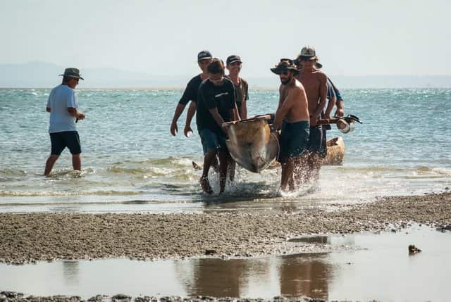 Smiling faces. The Saltwater Story canoe journey arrives on Goompin (Dunich) North Stradbrooke Island Quandamooka Yoolooburrabee.