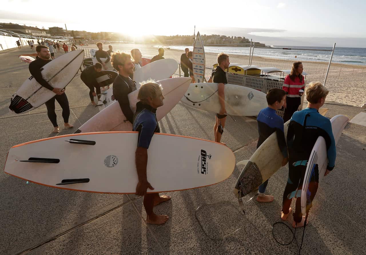 Surfers wait for officials to open Bondi Beach on Tuesday as the beach was partially reopened.