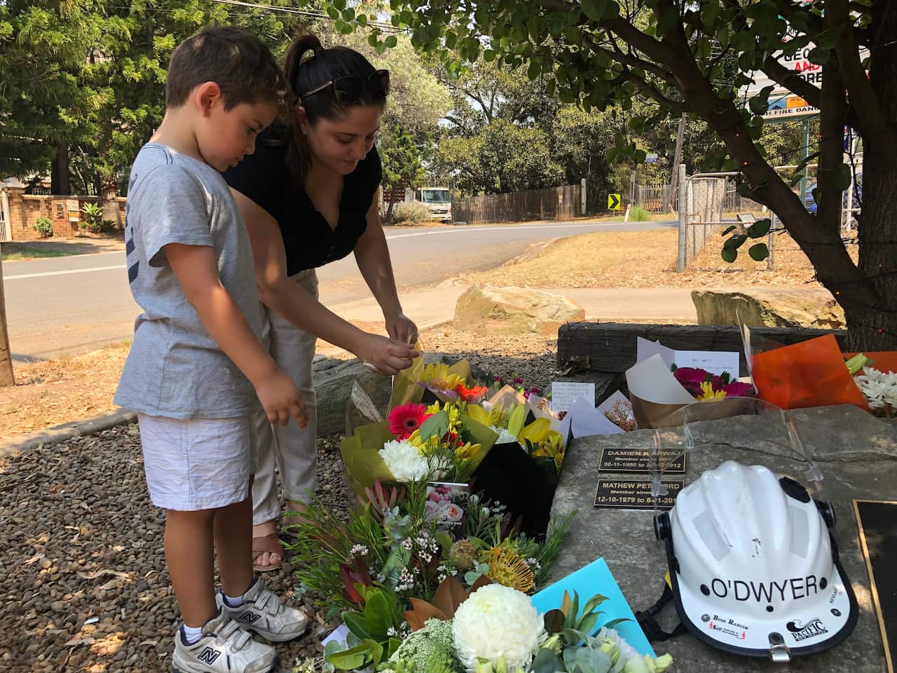 Dalia Matti and her son lay flowers outside the Horsley Park Rural Fire Brigade.