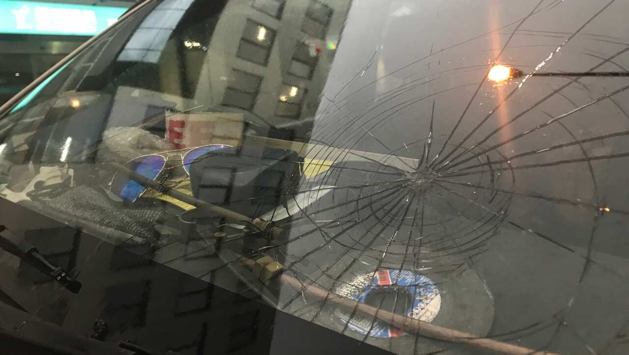 A cracked windshield from hail damage.