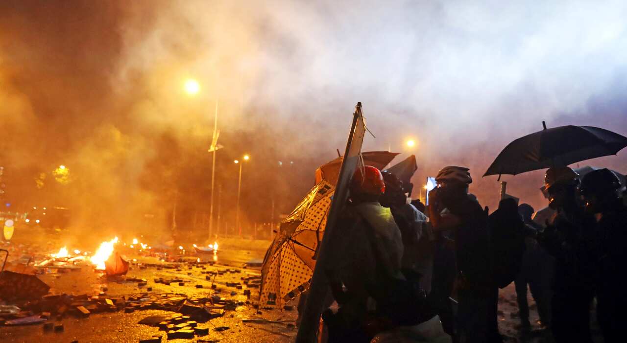 Protesters are thrown tear bombs by police officers on the street near Hong Kong Polytechnic University in Hong Kong on 17 November, 2019.