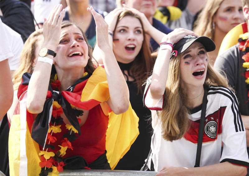 Soccer fans react after Germany was eliminated from the World Cup as they watch the group F World Cup match between South Korea and Germany.