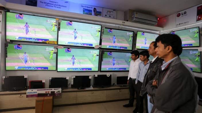 Indian cricket fans watch the live telecast of ICC World Cup Match between India and Pakistan in an electronics shop in India.