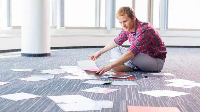 Businessman analyzing photographs while sitting on floor at creative office