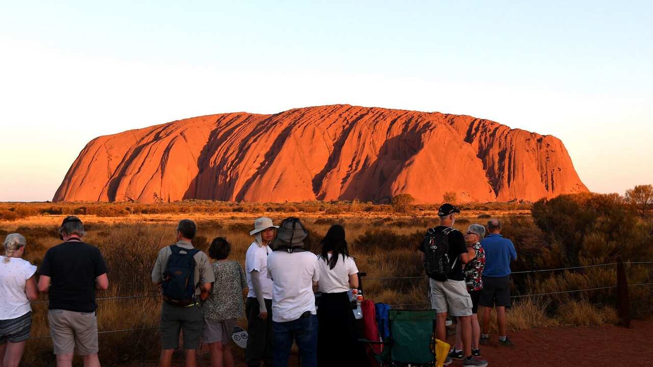 Tourists gather to watch sunset colours on Uluru, also known as Ayers rock.