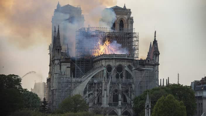 Smoke and flames rise during a fire at the landmark Notre-Dame Cathedral in central Paris