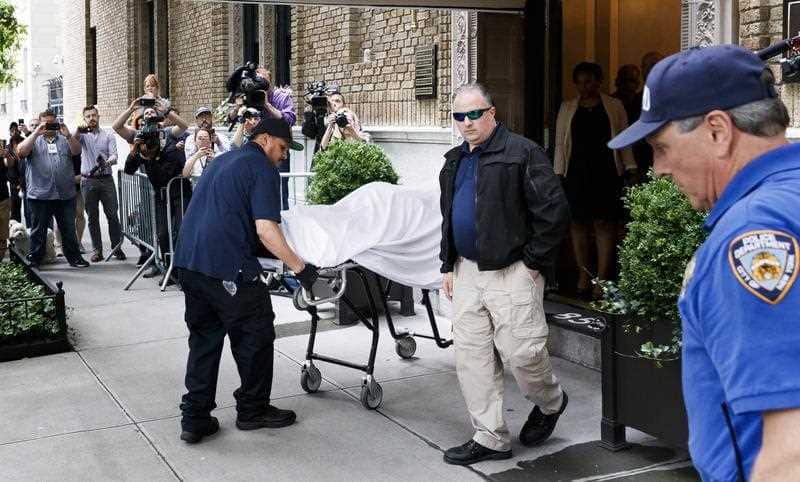 Members of New York's Chief Medical Examiner office transport the body of designer Kate Spade from her apartment building.