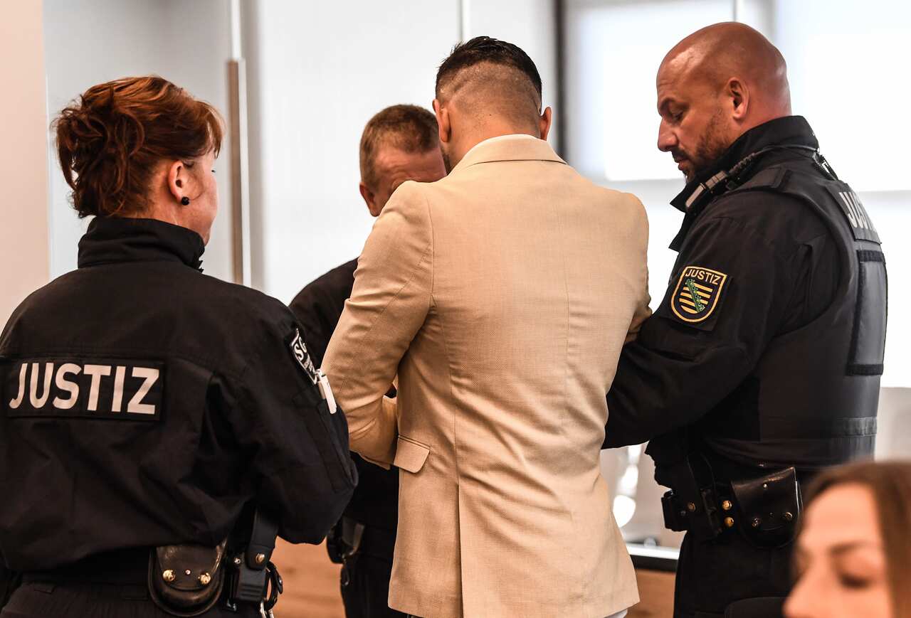Judicial officers lead defendant Alaa Sheikhi of Syria into a courtroom prior to the proclamation of the verdict in his trial.