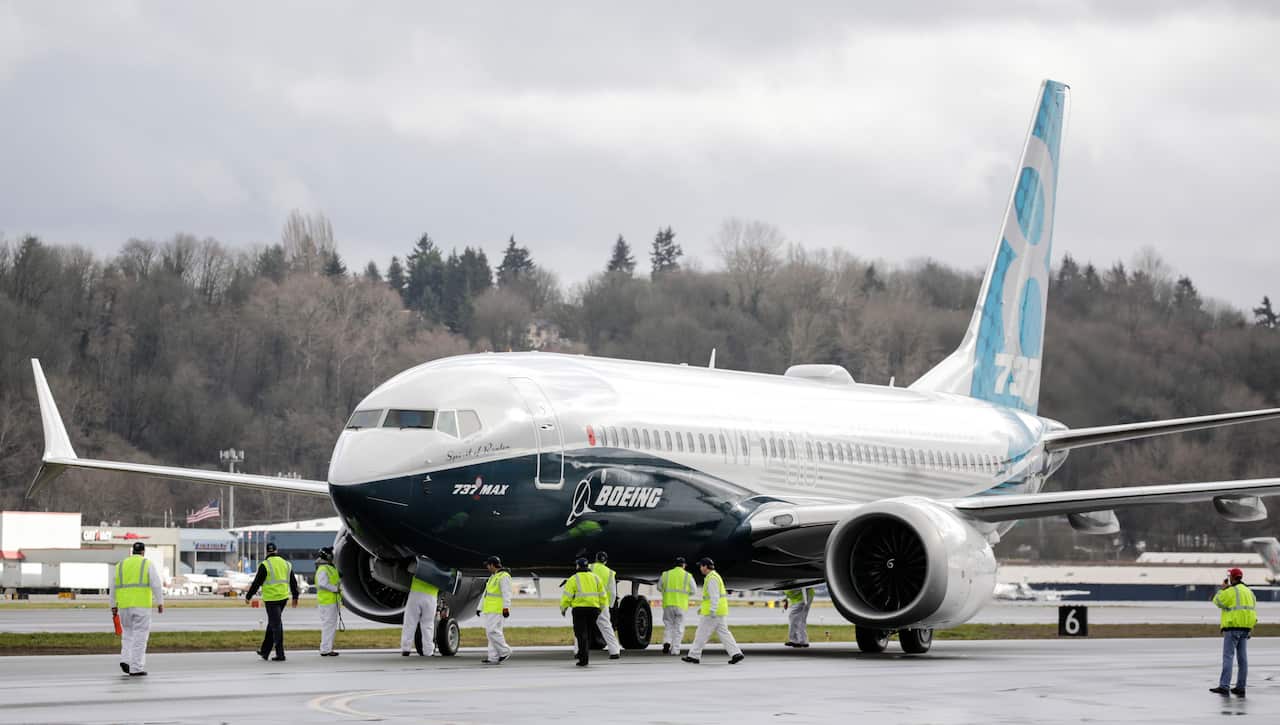 Ground crew check out a Boeing 737 MAX 8 airliner.