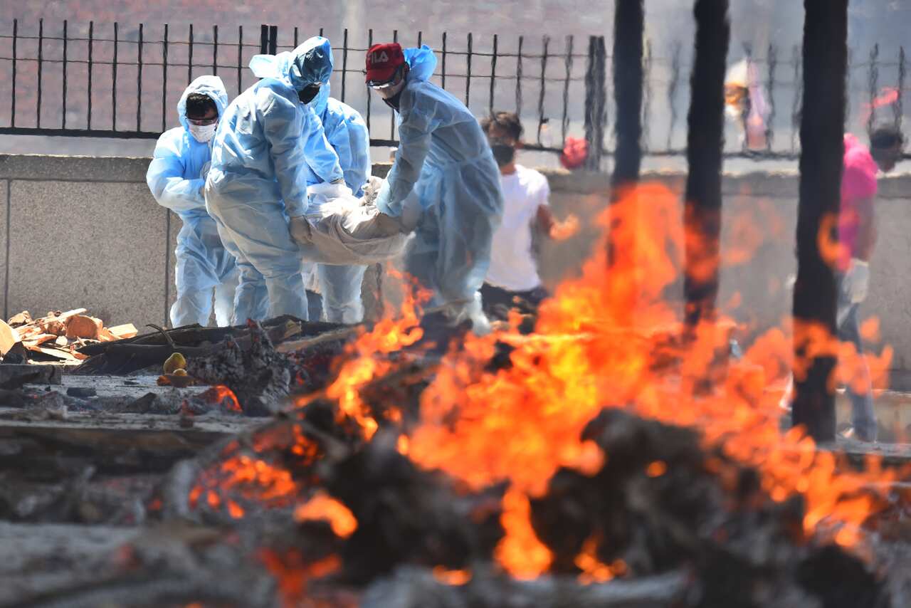 A body of a Covid-19 victim is carried for cremation, at Seema Puri crematorium.
