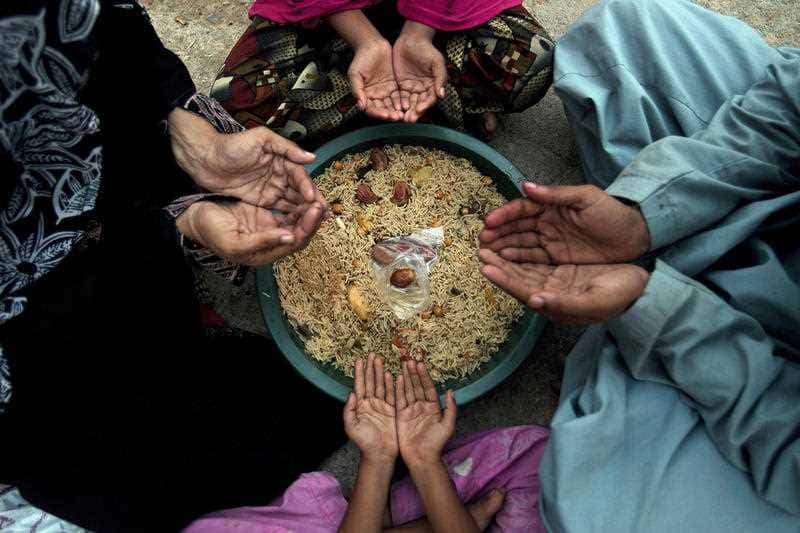 A family pray before breaking their fast during the Islamic month of Ramadan.