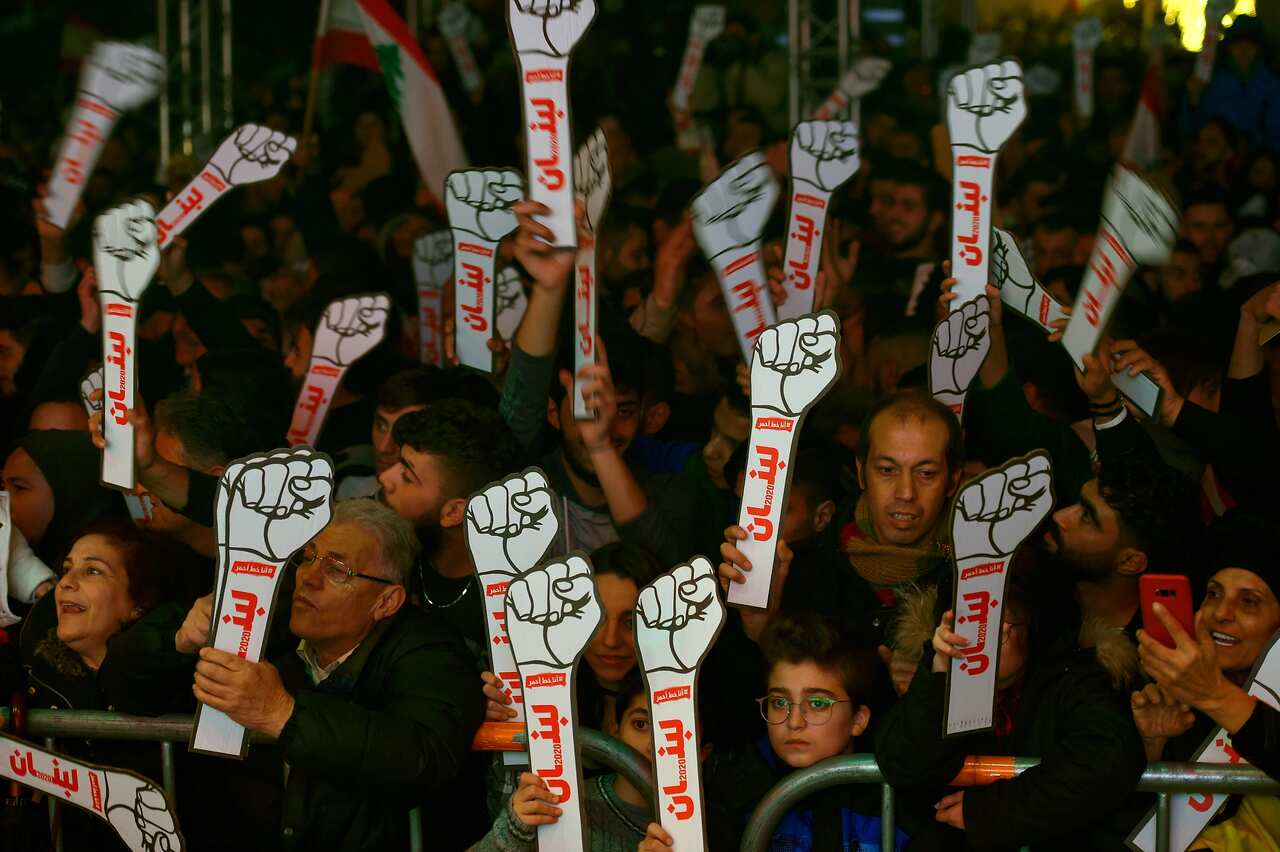 epa08097012 Lebanese anti-government protesters and citizens hold cut outs during New Year's Eve celebrations at Martyrs' Square in Beirut, Lebanon, 31 December 2020.  EPA/WAEL HAMZEH