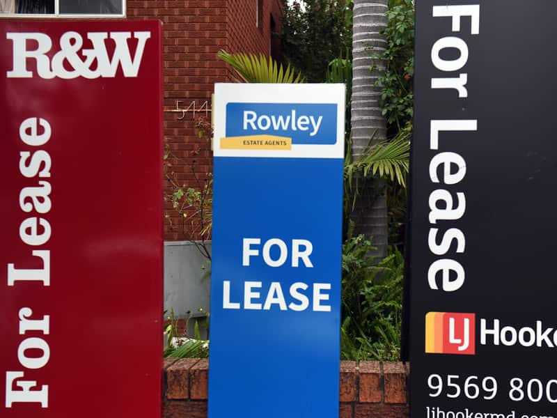 For Lease signs outside a block of apartments