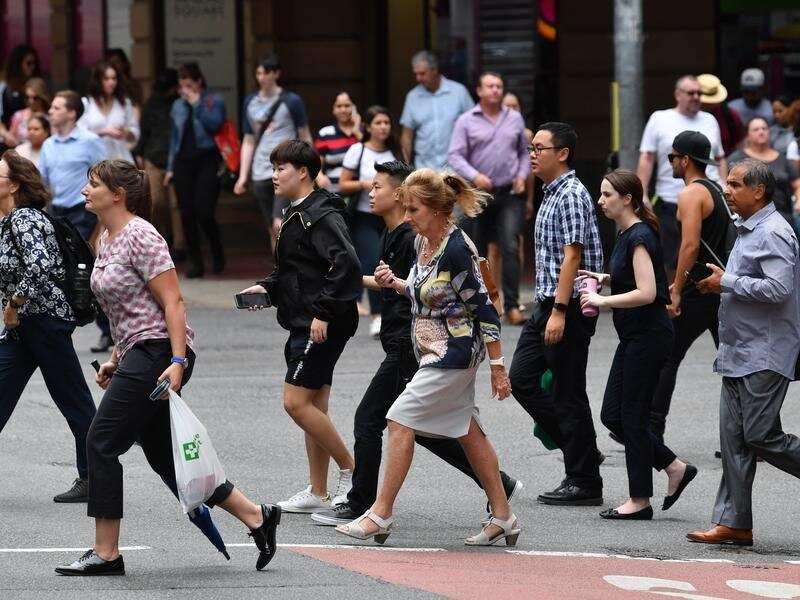 Pedestrians cross an intersection in the Brisbane CBD